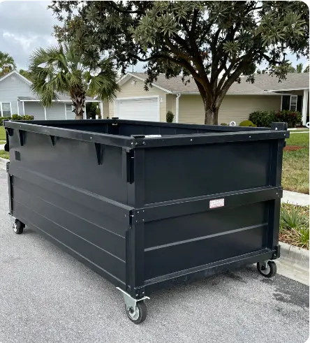 Large open-top dumpster on wheels parked at a residential curb